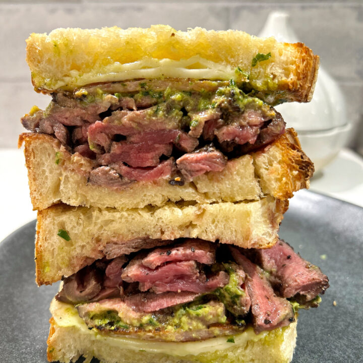 steak and cheese sandwich on a black plate
