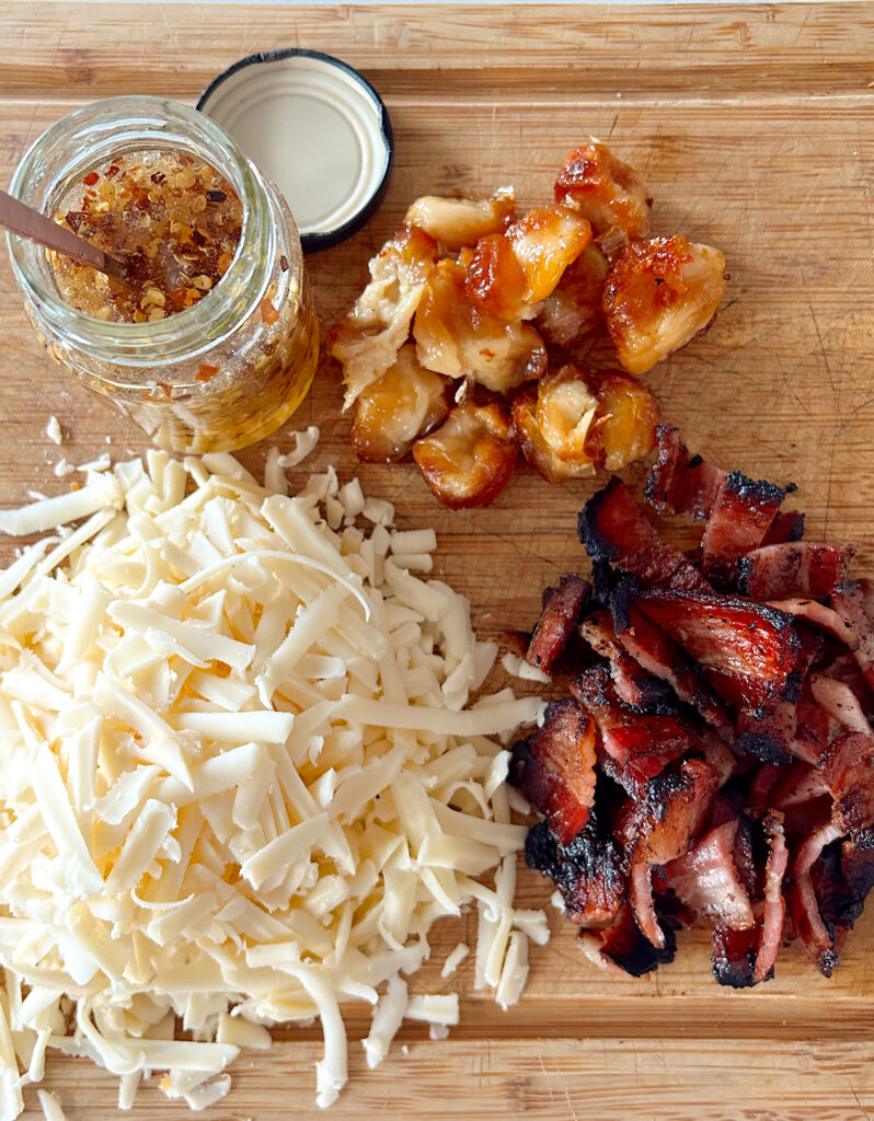 cheese, bacon, garlic and honey on wood board.