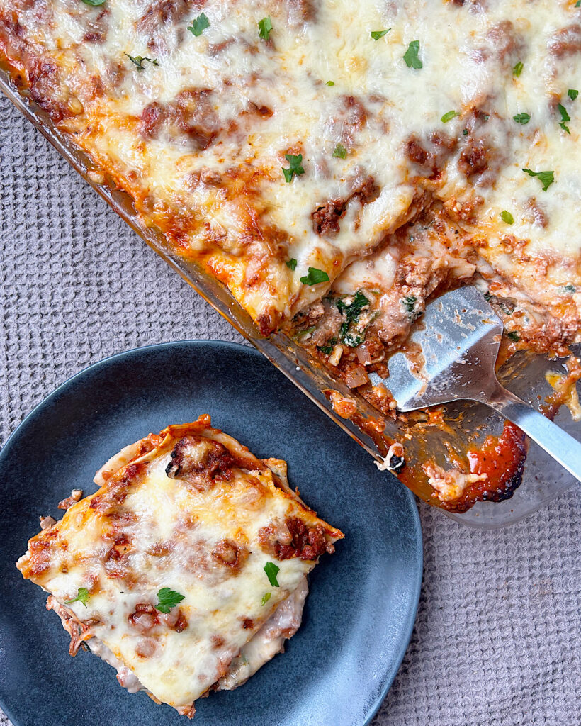a pan of lasagna with a piece cut out of it