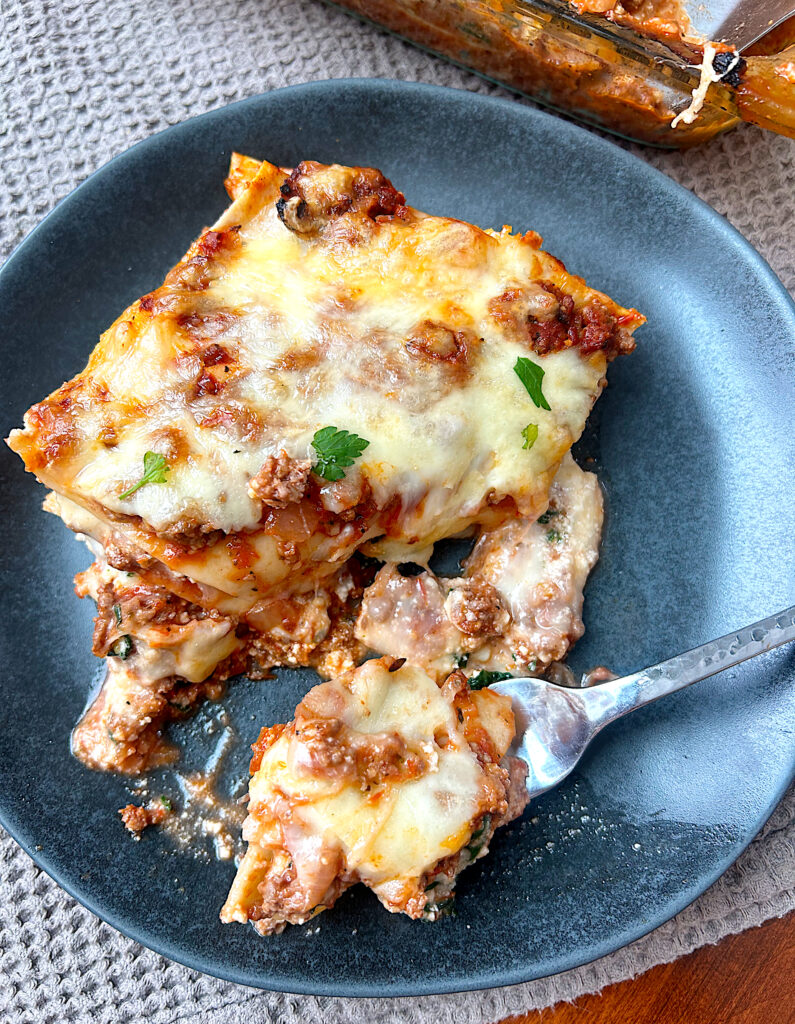 a piece of homemade lasagna on a blue plate