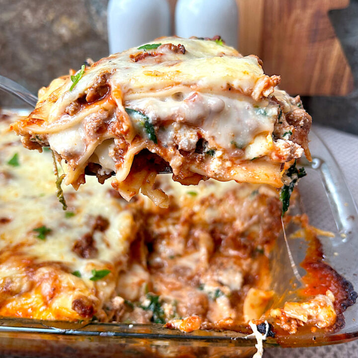 a piece of lasagna being lifted out of the baking pan