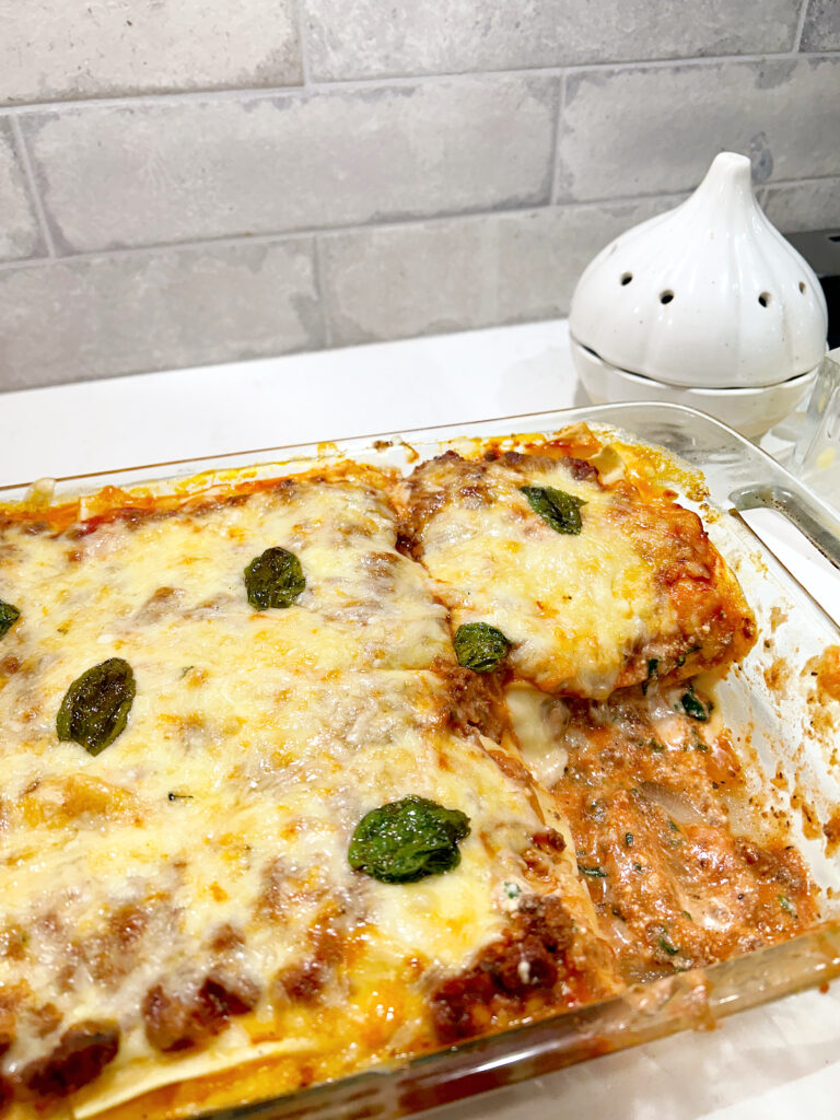 baked lasagna on a white counter with grey brick backsplash