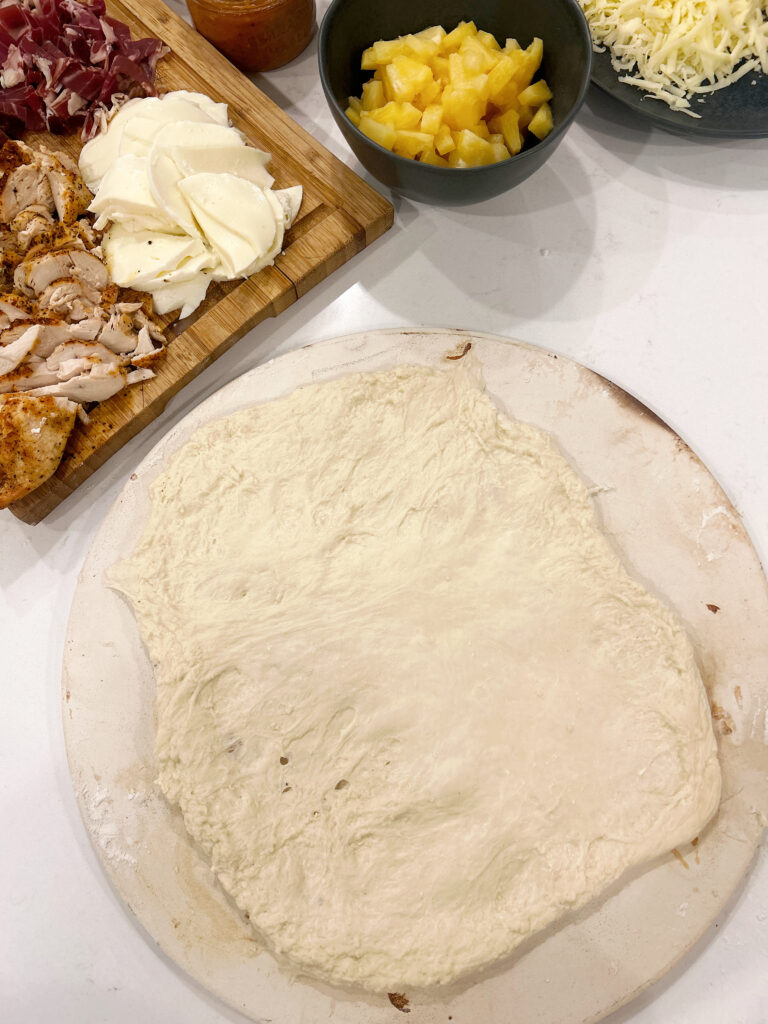 Pizza dough stretched onto a pizza stone