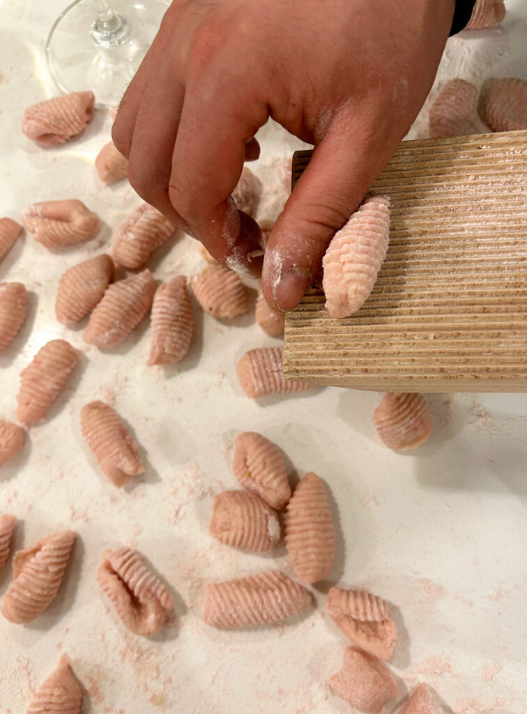 pink gnocchi being made on a white counter