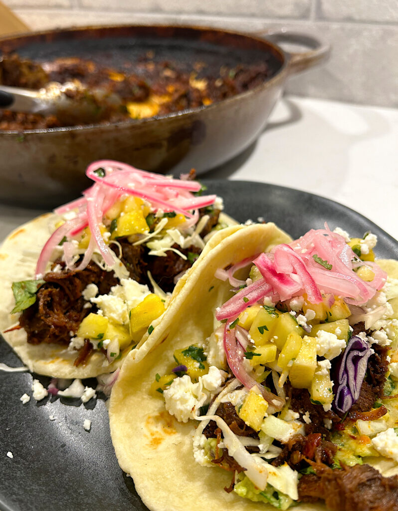 tacos with shredded meat and pineapple salsa