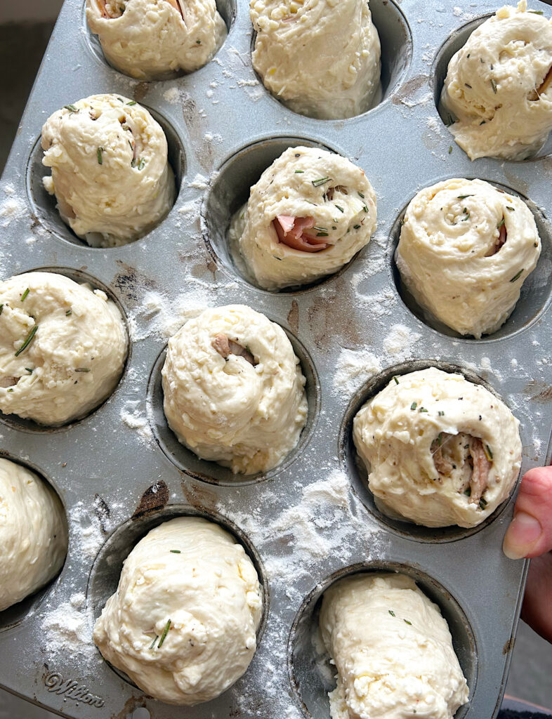 unbaked bread rolls in a muffin tin