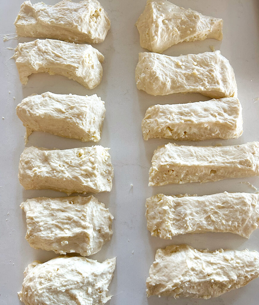 sourdough bread dough cut into pieces on a white counter