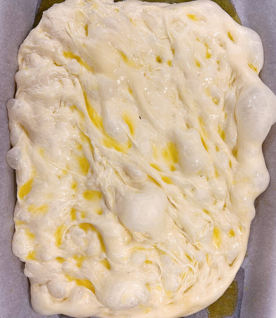 bread dough on a baking sheet with butter