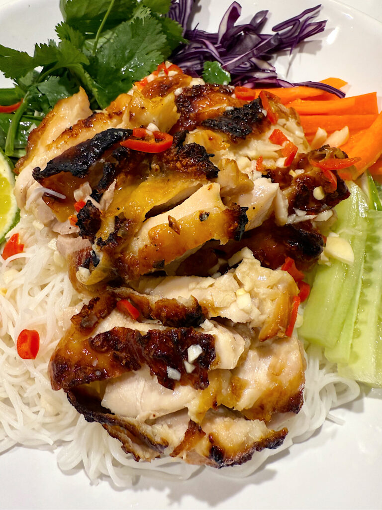 bowl of rice noodles with vegetables and chicken