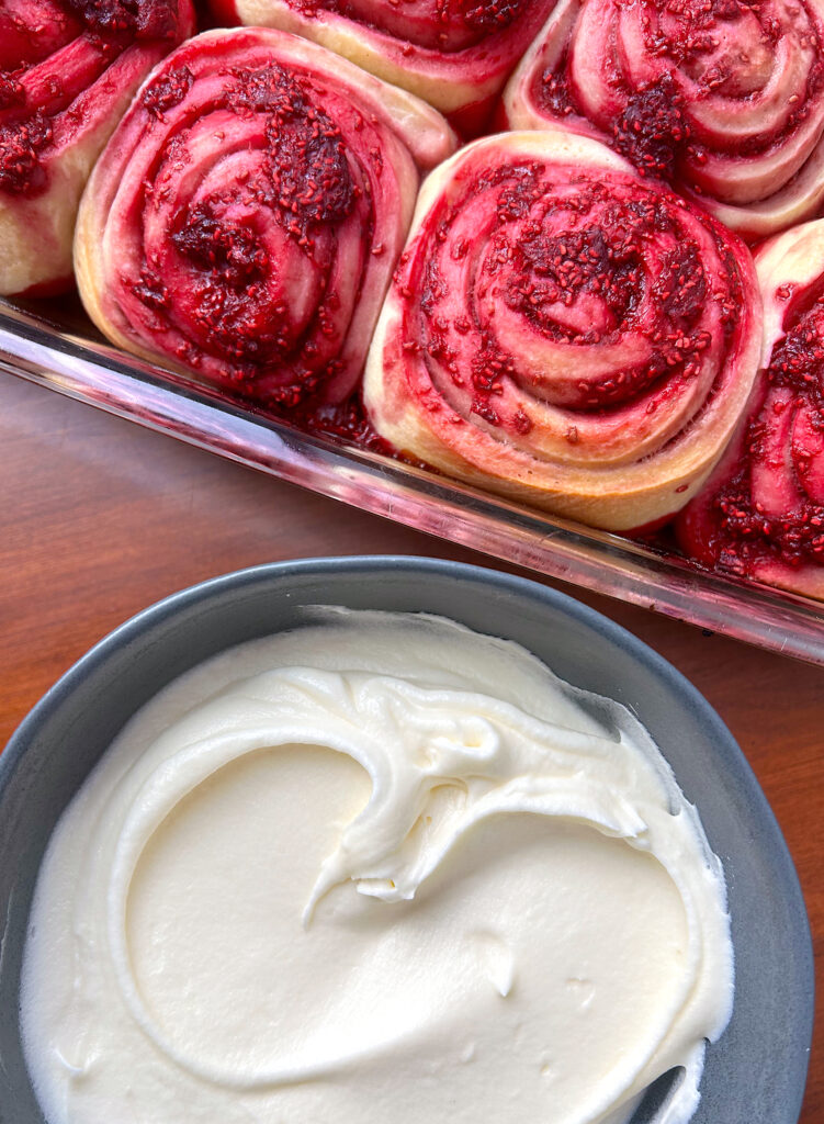 sweet rolls with raspberry filling and a bowl of cream cheese icing