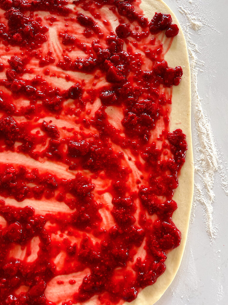 dough rolled into a rectangle, with raspberry filling on top