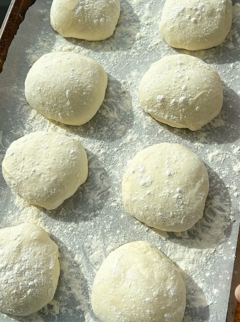 unbaked buns on a baking sheet