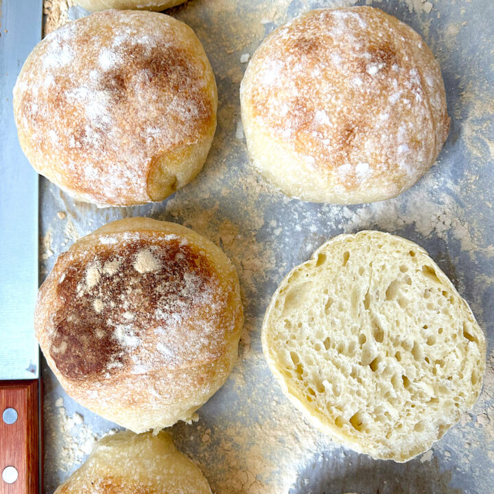 fresh baked hamburger buns on a baking sheet