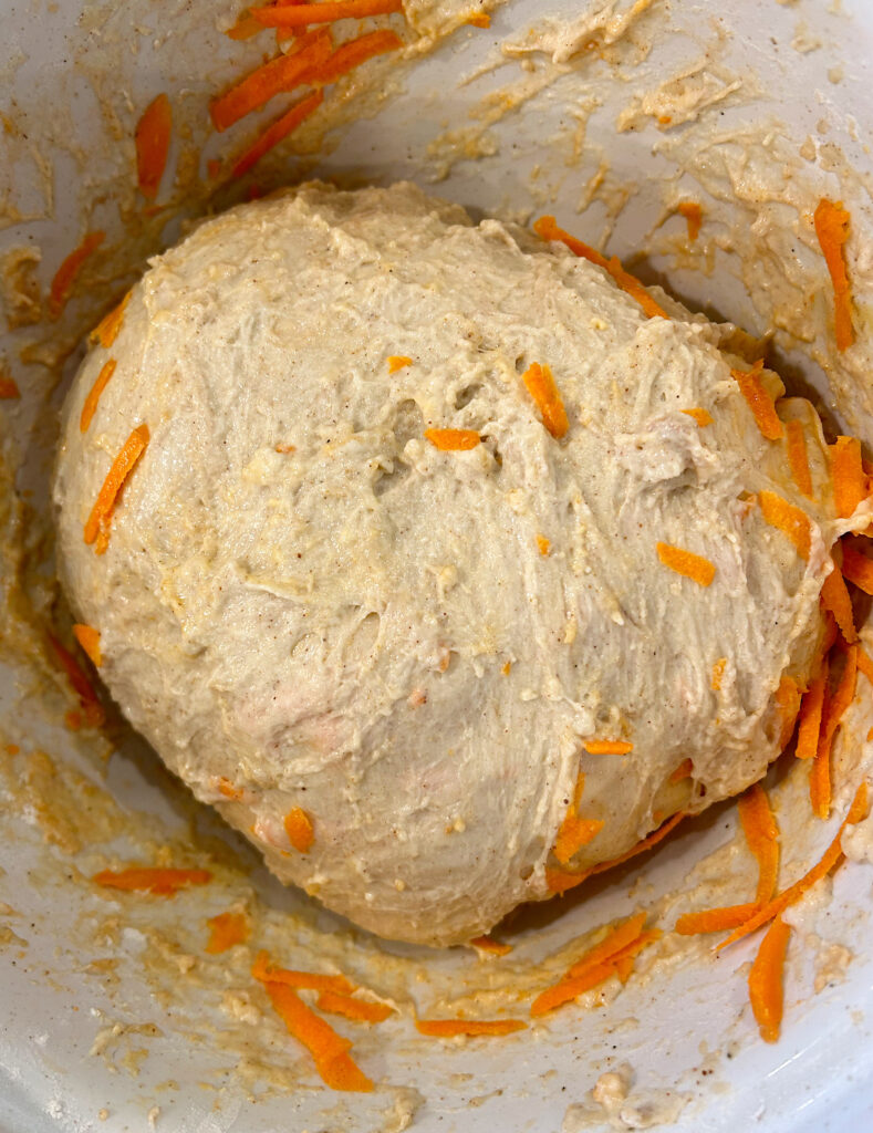 bread dough with grate carrots in a bowl