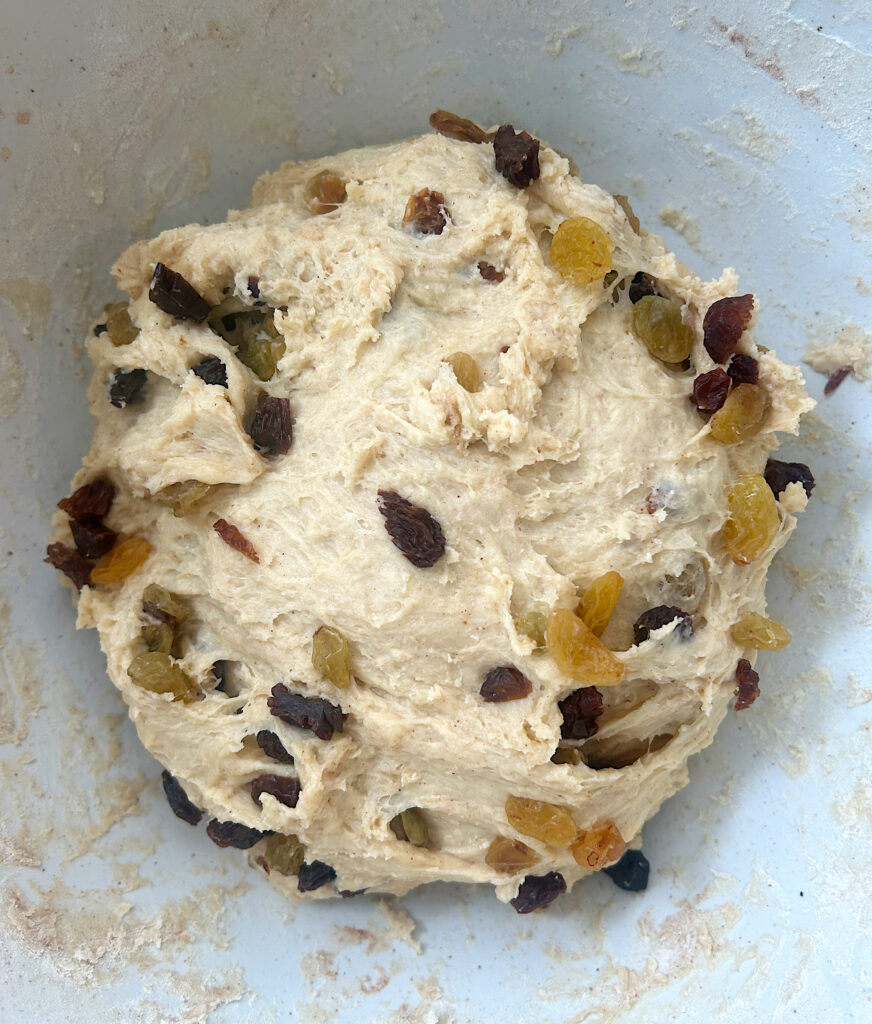 sourdough bun dough with raisins in a white bowl