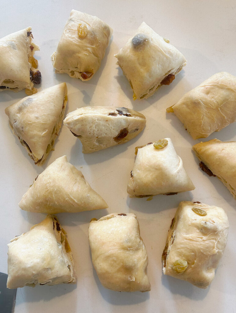 sourdough bun dough cut into pieces on a white counter