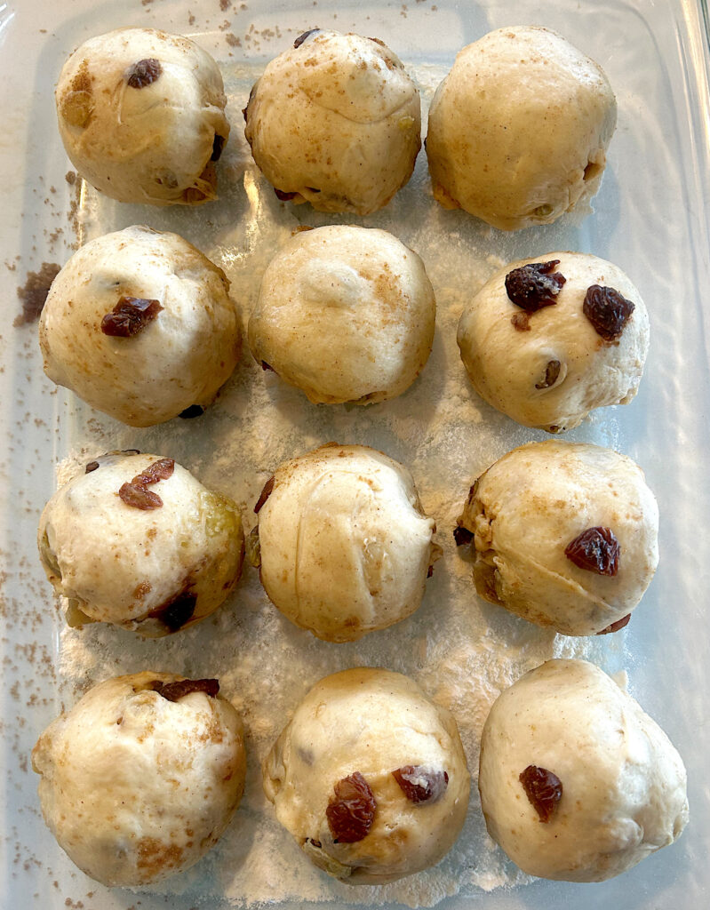 unbaked sourdough buns with raisins in a glass baking dish