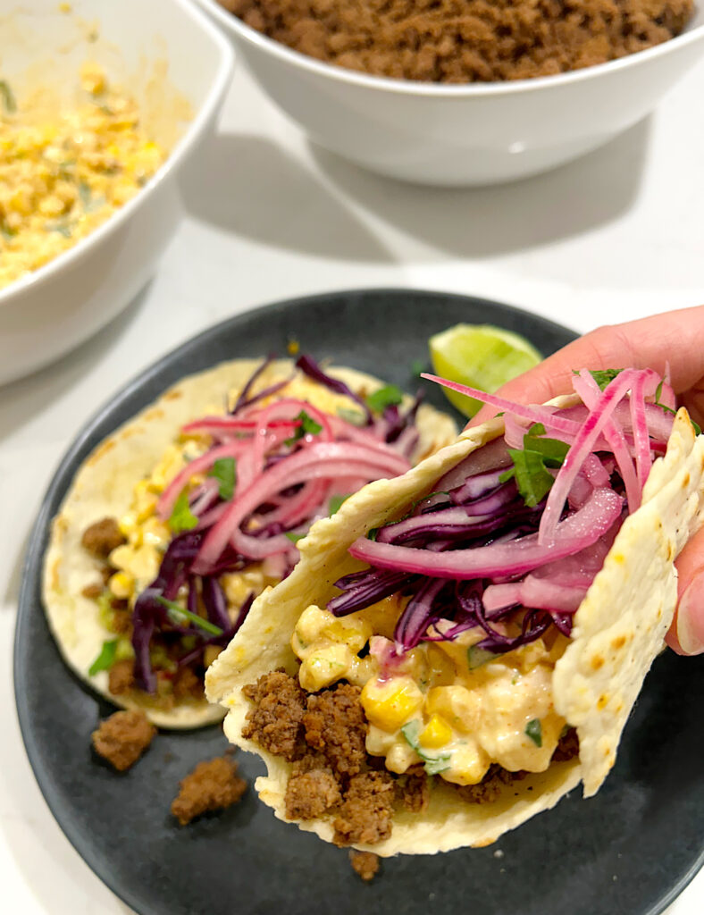 tacos with ground meat, creamy corn filling and pickled red onions
