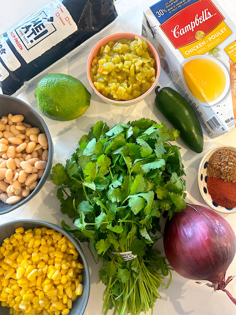 cilantro, corn, beans and spiced on a white counter