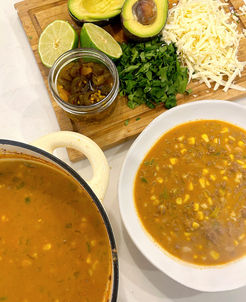 corn chili in a white bowl with fresh toppings on the side
