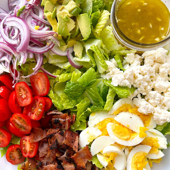 bowl of lettuce, bacon, egg, avoacado, tomato and feta cheese