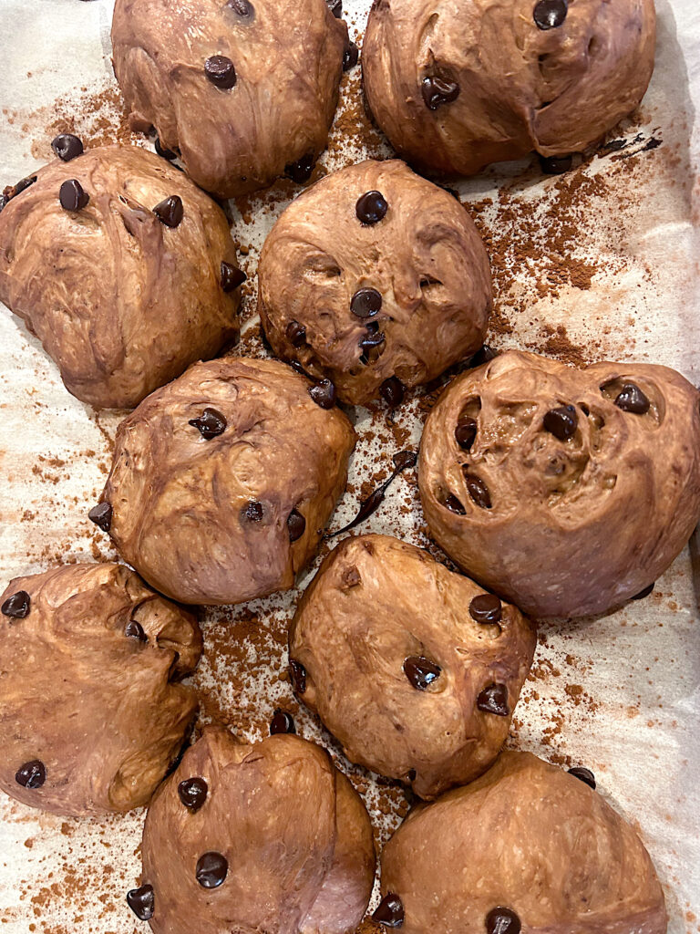 chocolate dough balls proofing on a baking sheet