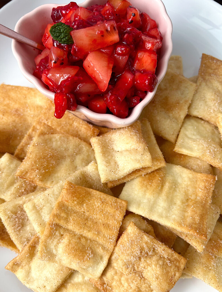 crackers on a plate with fruit salsa in a small bowl