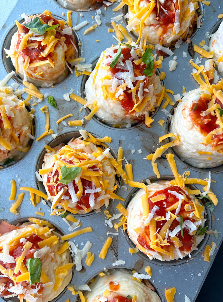 unbaked pizza buns in a muffin tin