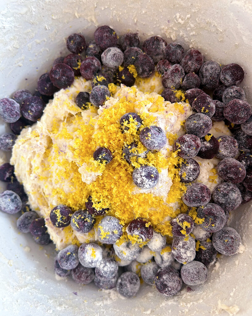 bowl of bread dough with blueberries and lemon zest