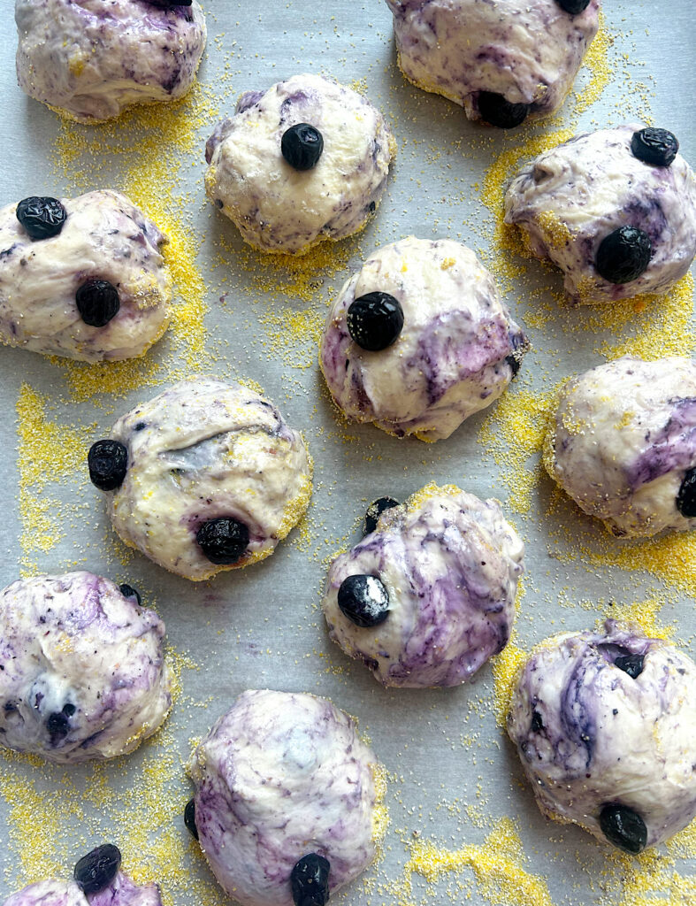ubaked blueberry english muffins on a bking sheet