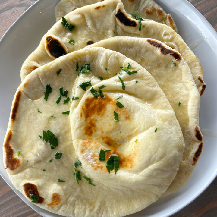 sourdough naan bread on a white plate