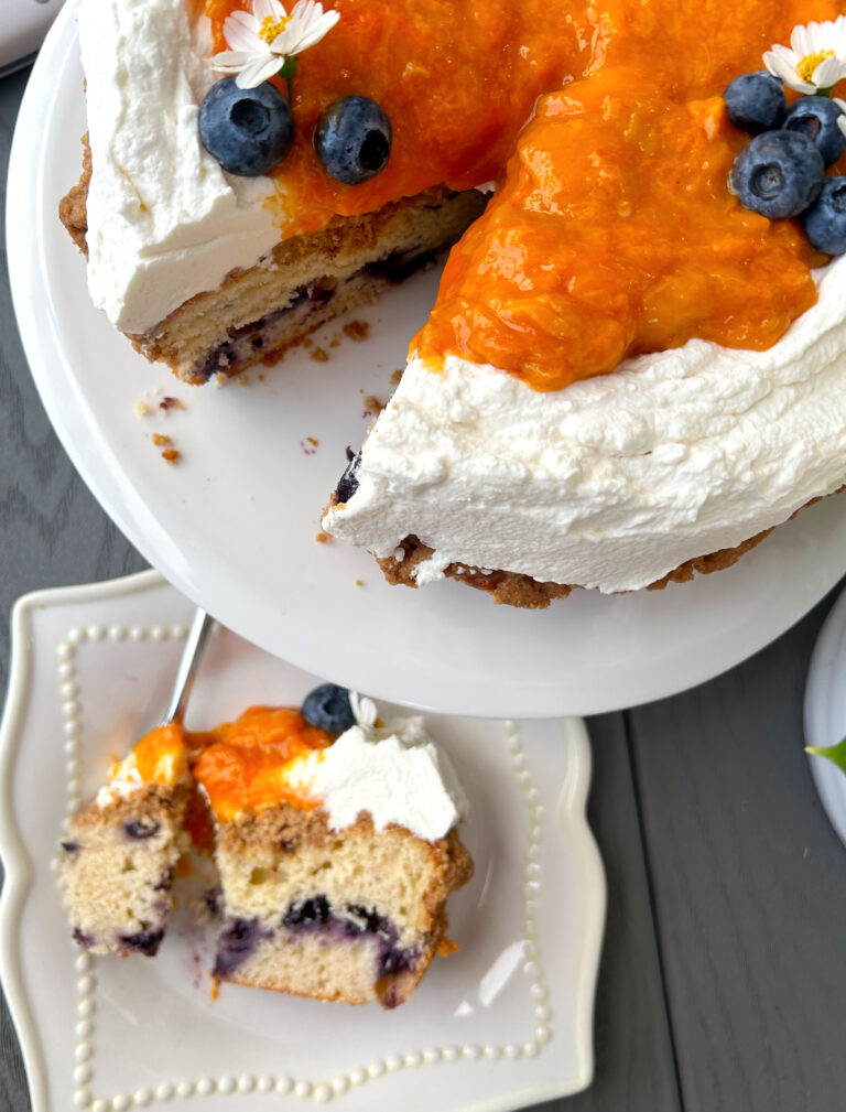 round cake with whipped cream and peaches on top