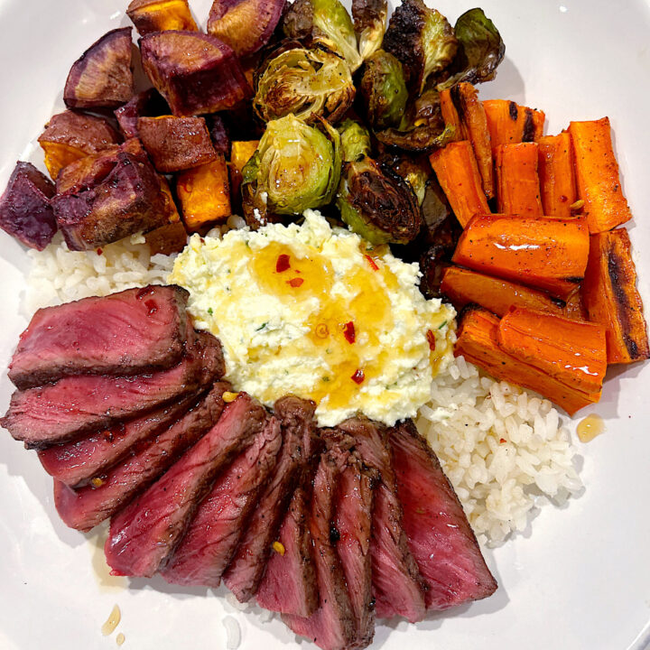 rice bowl with roasted, vegetables, whipped feta, steak and hot honey