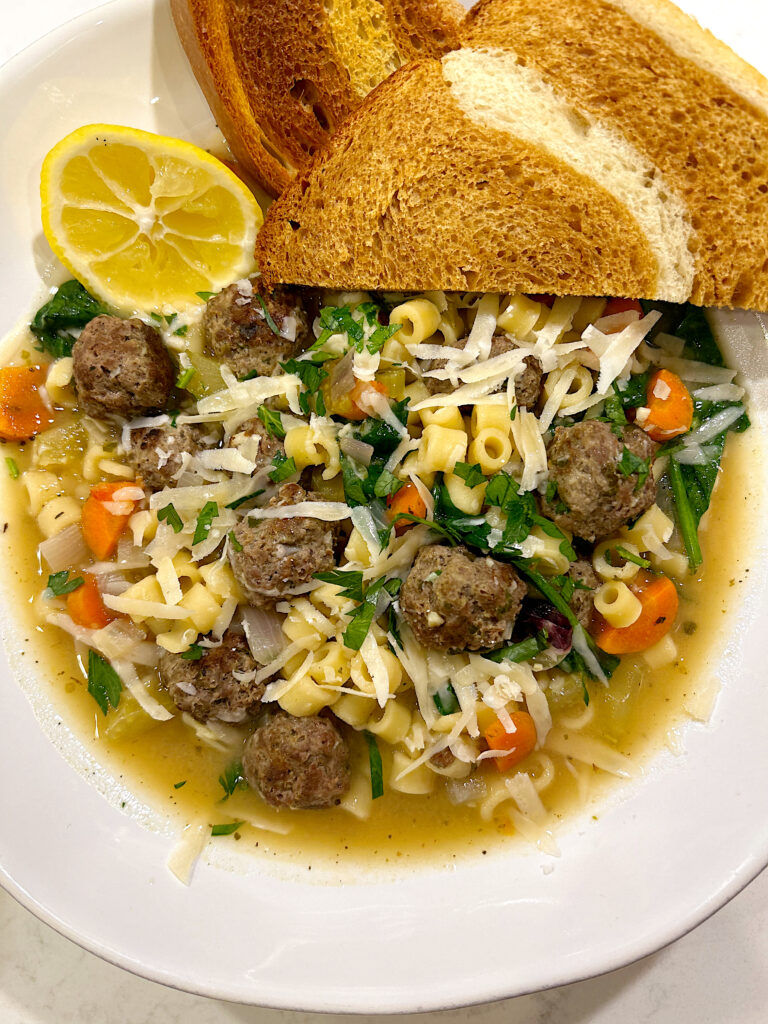 bowls of noodle and meatball soup with sourdough bread