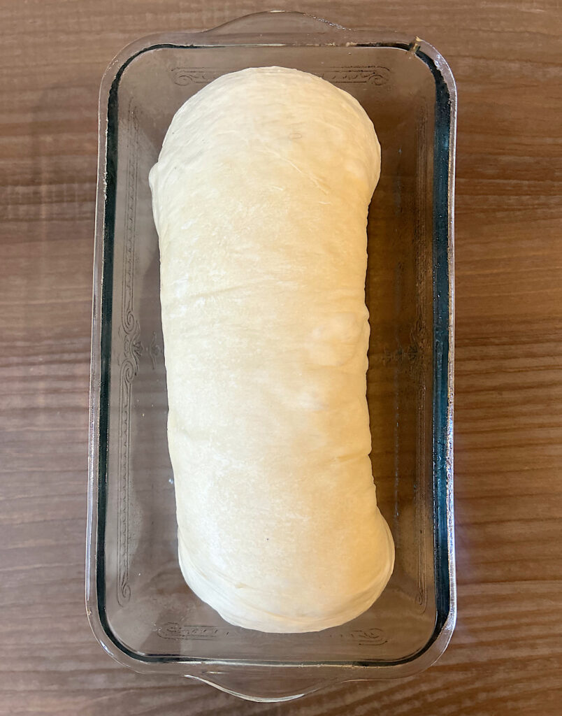 log of bread dough in a loaf pan