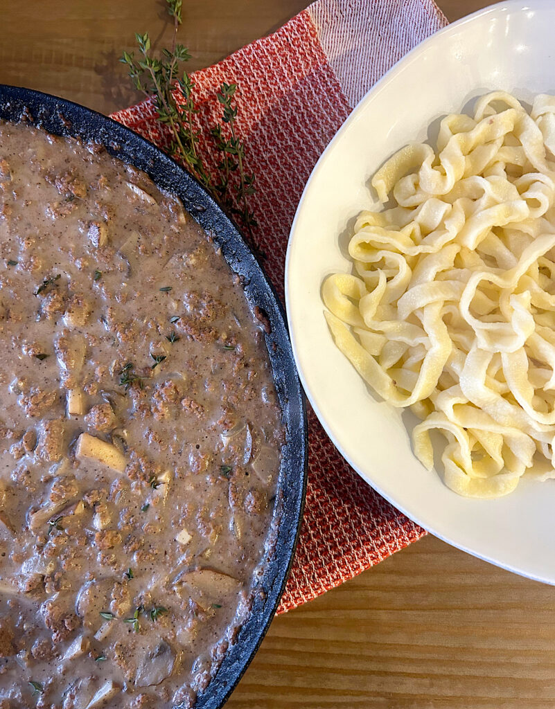 sourdough noodles in a bowl with stroganoff sauce in a pan 