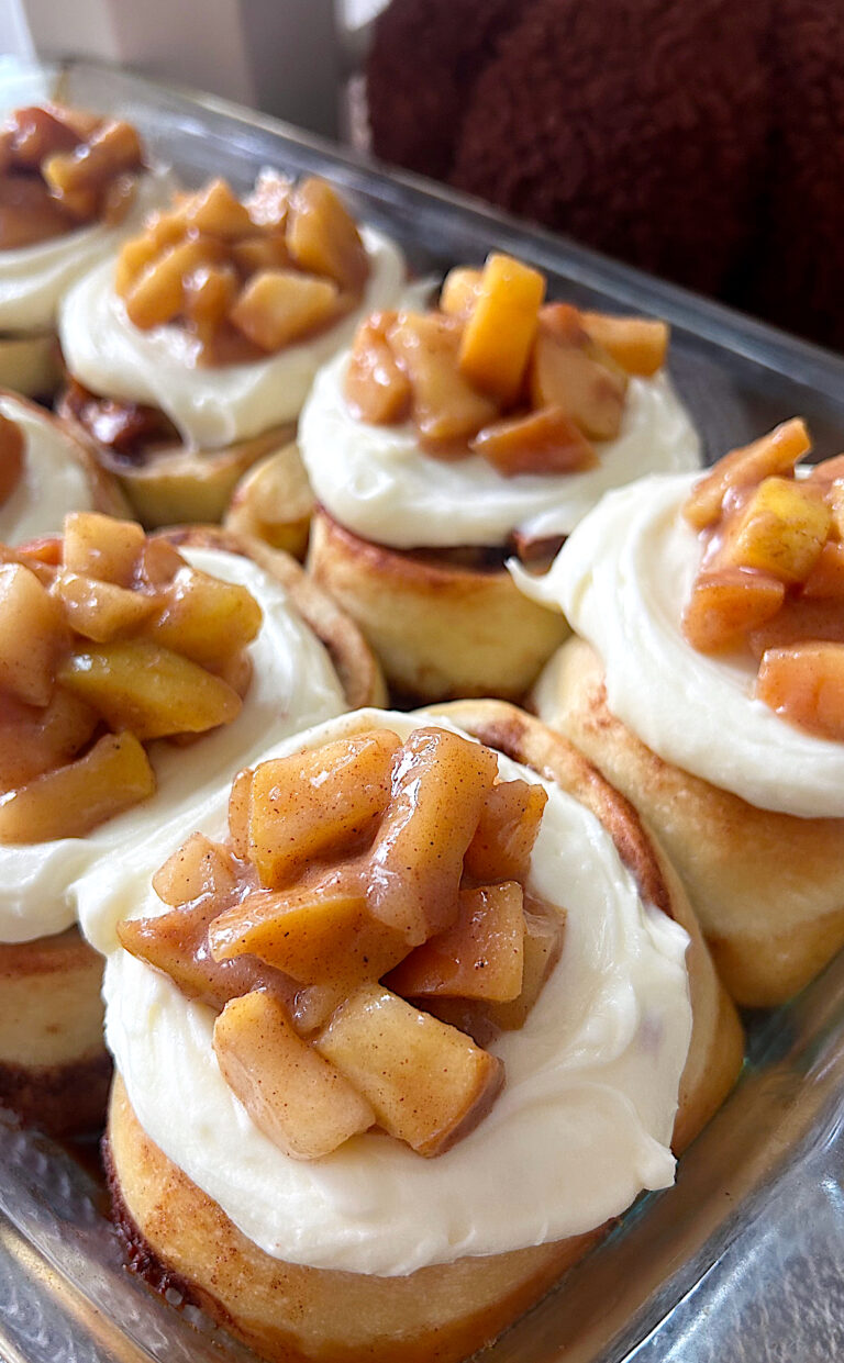 cinnamon buns with cream cheese icing and apples on top