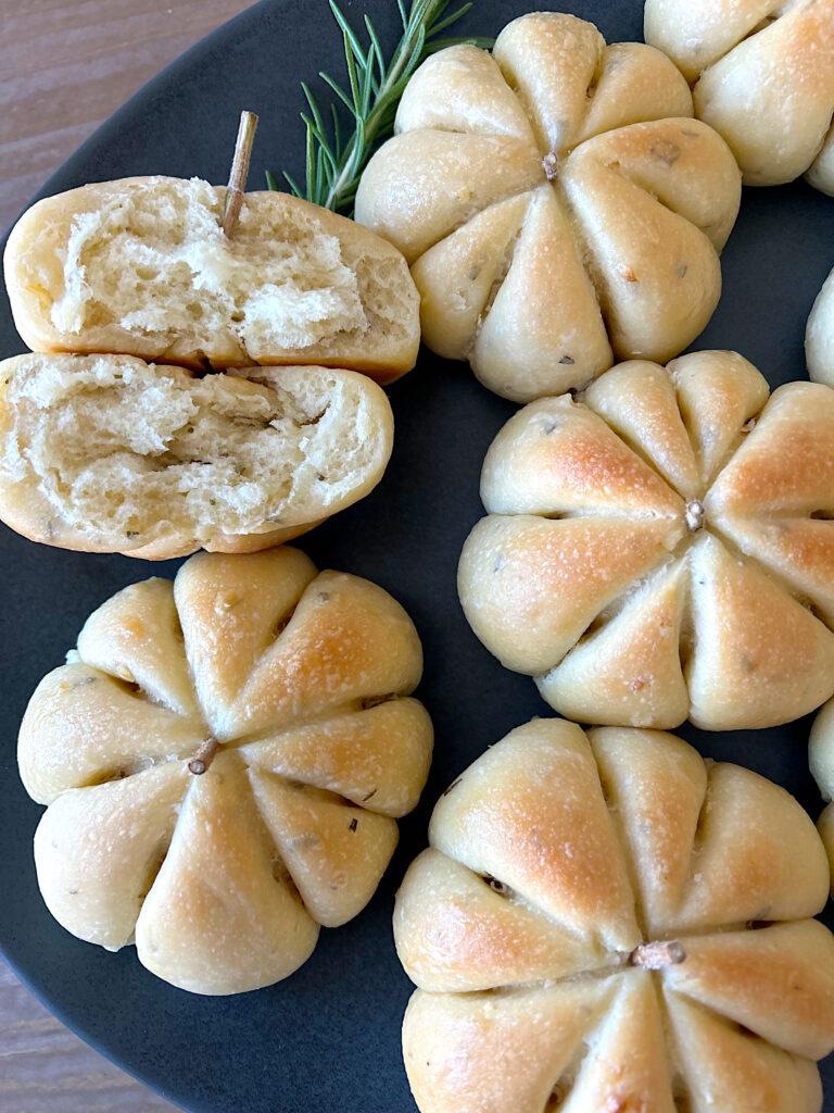 pumpkin shaped sourdough buns on a dark blue plate