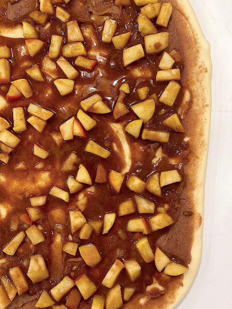 bun dough, topped with brown sugar and apple pie filling