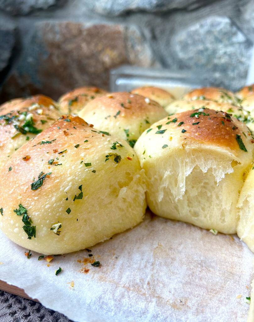 a batch of soft dinner rolls with herbs
