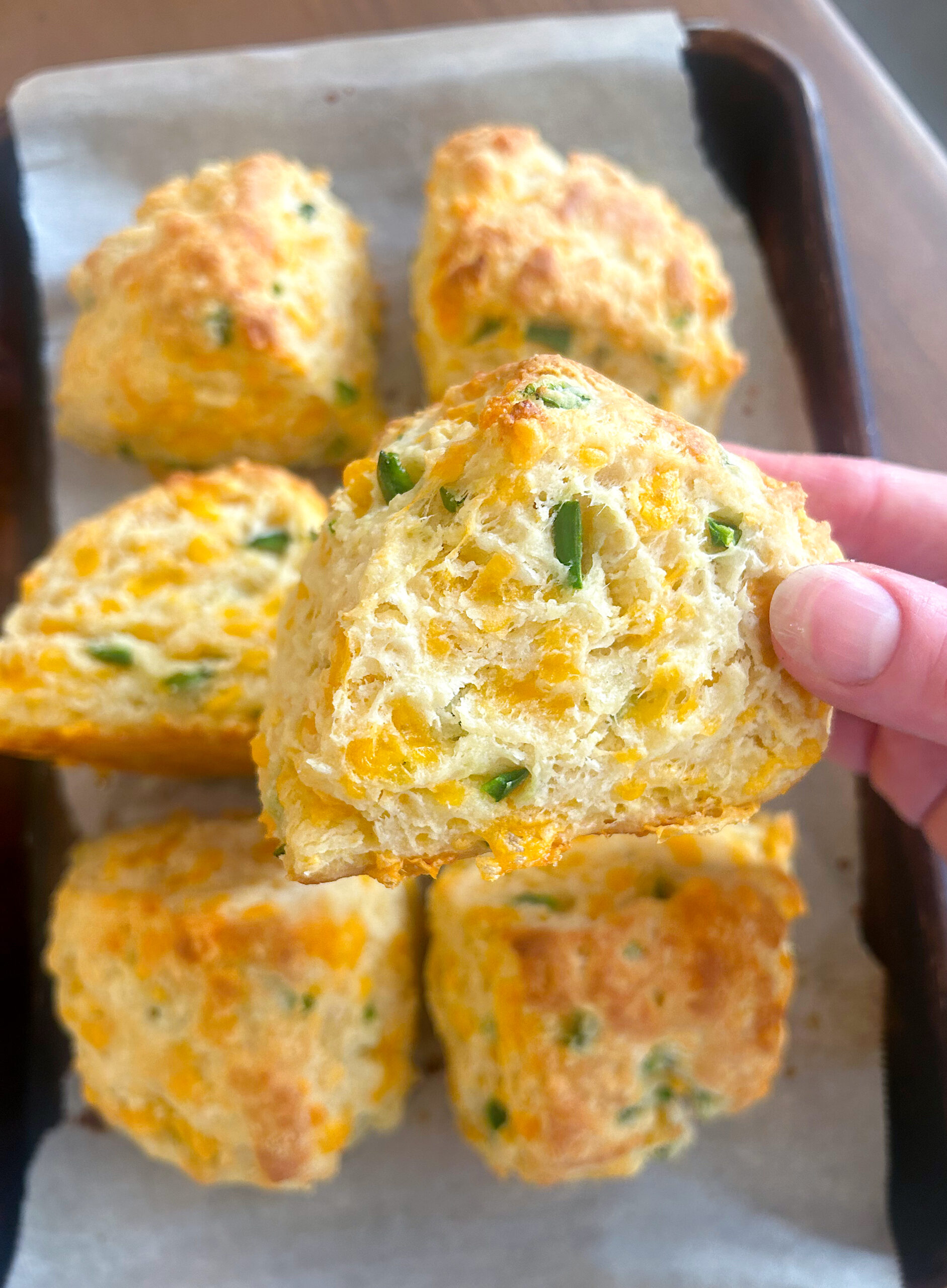 buttery jalepeno cheddar sourdough biscuits on a baking sheet