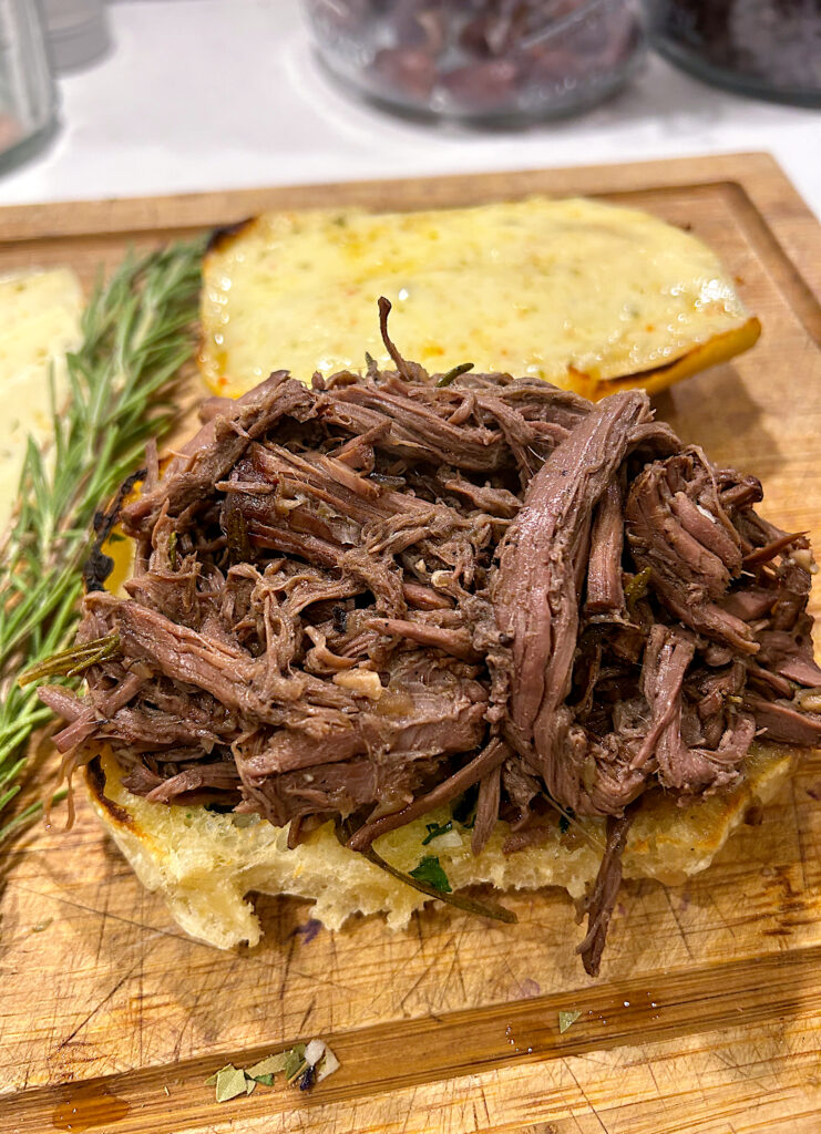 sandwich with shredded venison meat on a wood board
