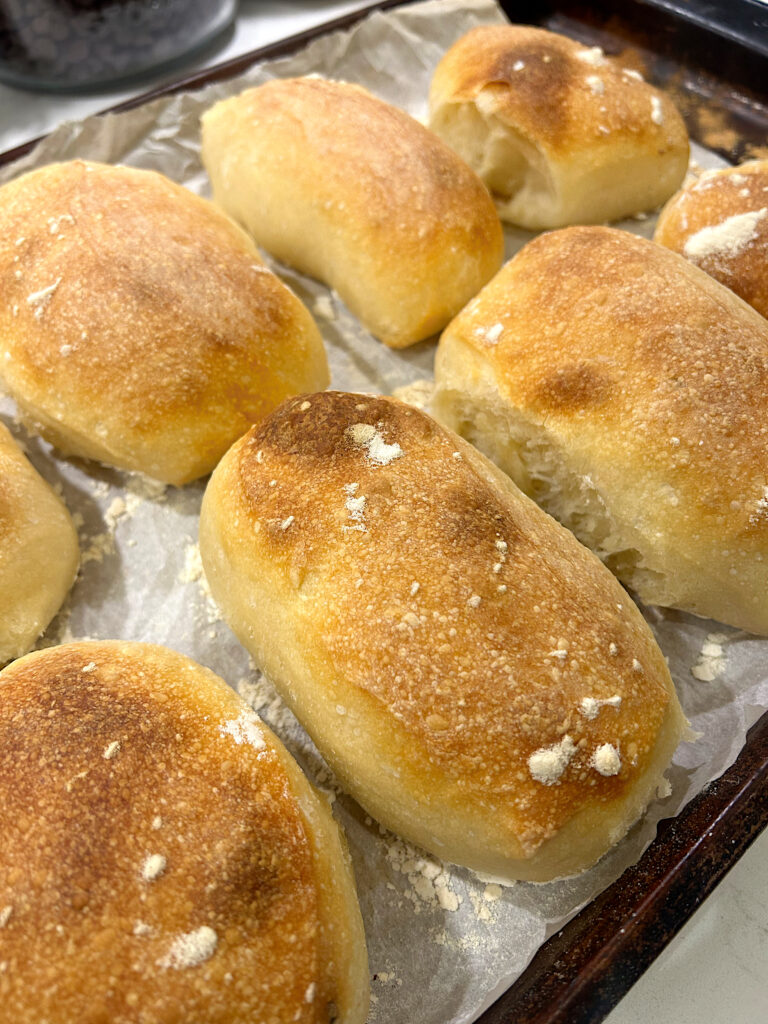 fresh baked sourdough buns on a baking tray
