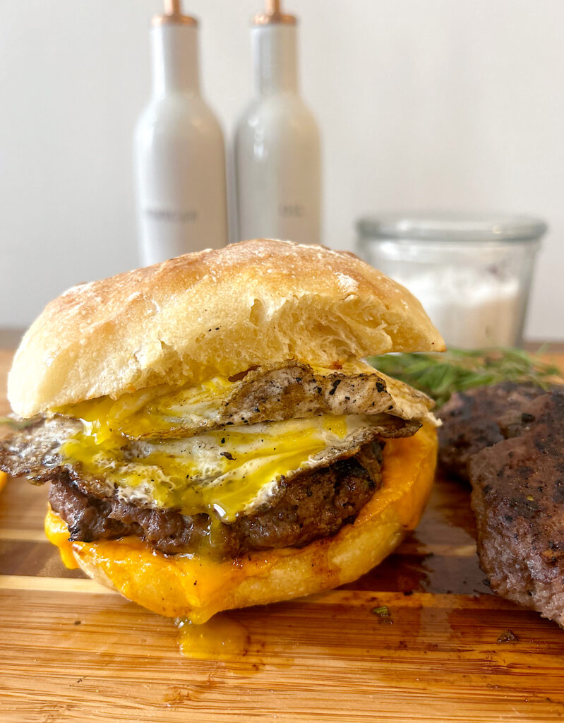 sausage and egg breakfast sandwich on a wood board