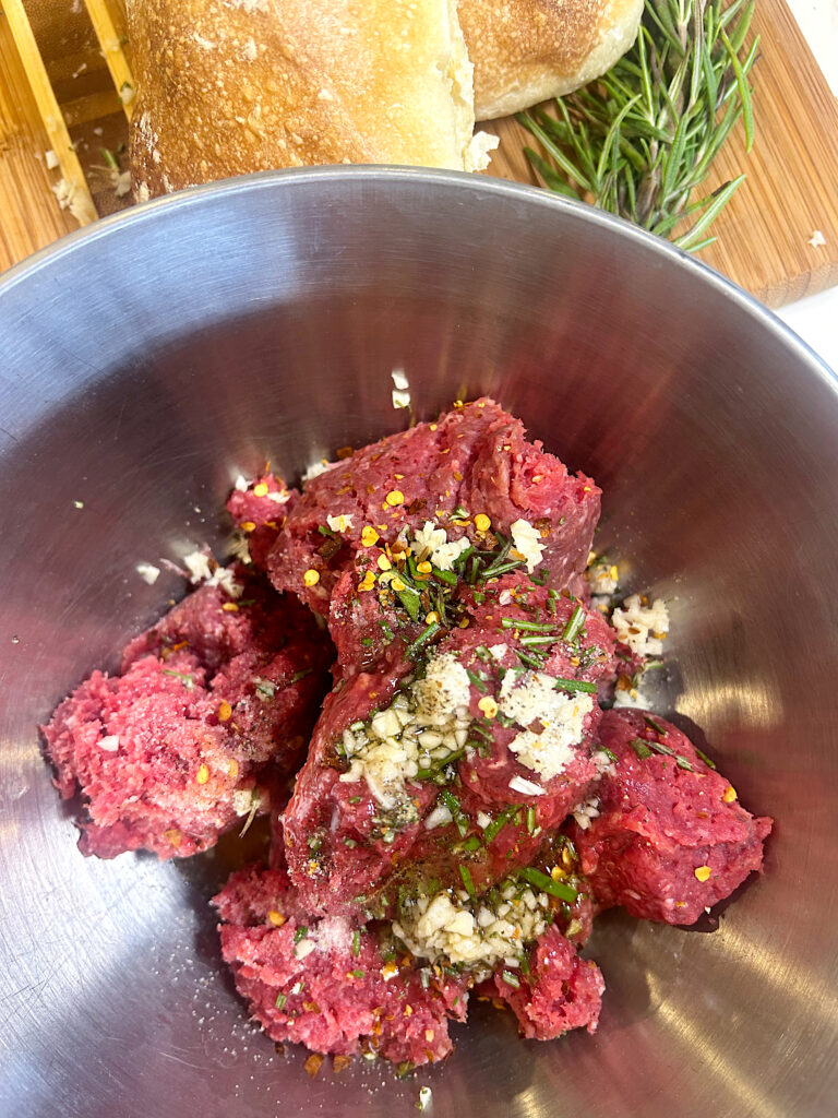 ground meat with garlic and spiced in a metal bowl