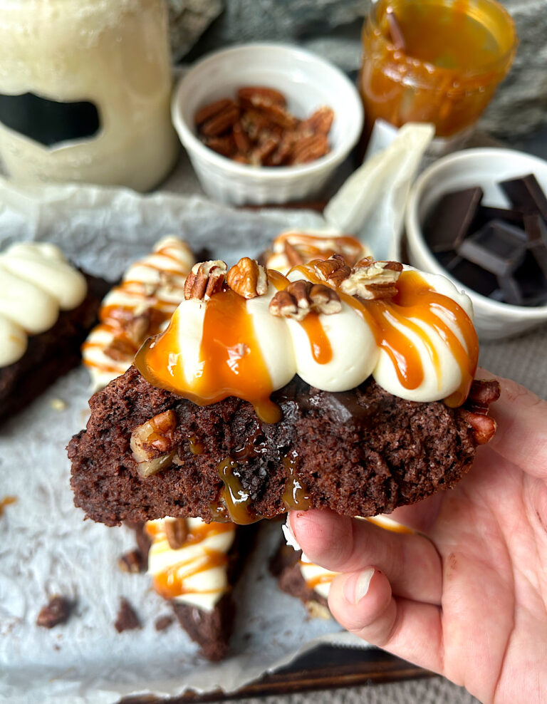 a chocolate scone with cream cheese icing, caramel sauce and pecans