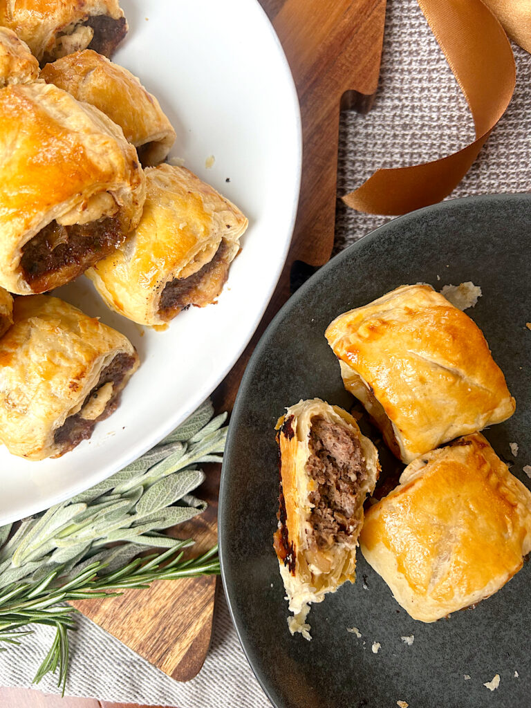 a black plate and a white plate with little sausage rolls 