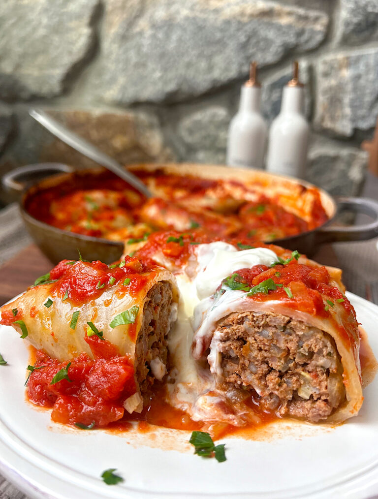 a white plate with a meat cabbage roll cut in a half