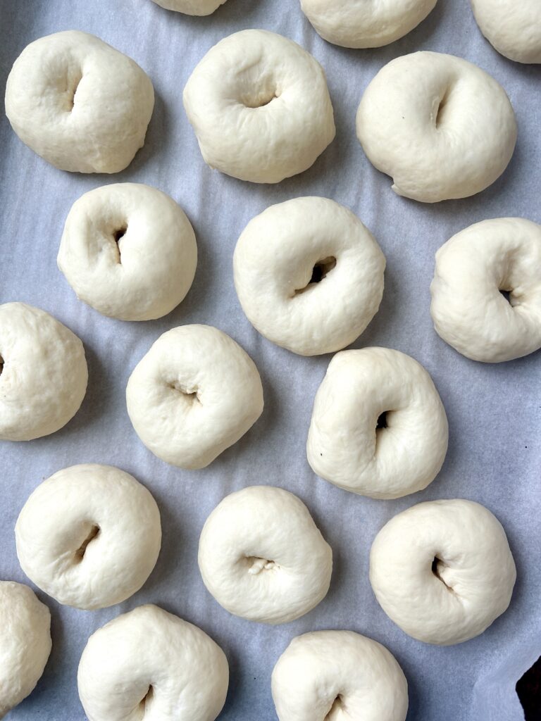 puffy unbaked mini bagels on a baking sheet