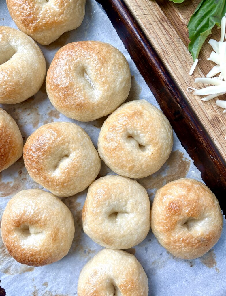 golden baked mini bagels on a baking sheet
